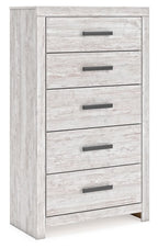 Whitewash five-drawer chest with five dark bar pulls visible on front face