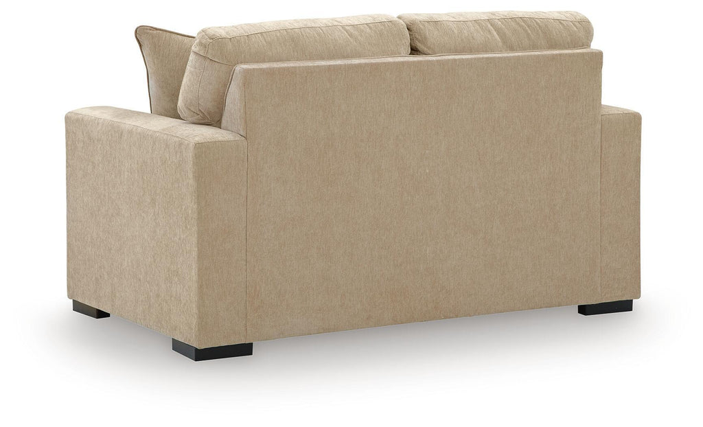 Light tan upholstered loveseat with two back cushions and wide arms