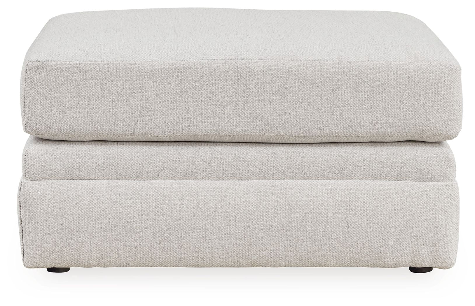 Light beige ottoman with layered rectangular sides, flat top cushion, short feet