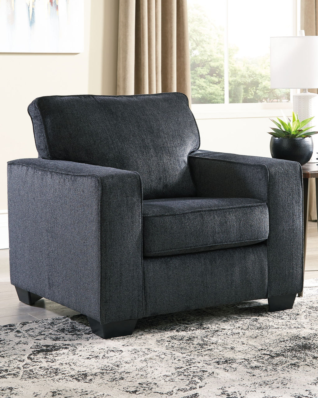 Dark gray fabric arm chair with rounded back, padded arms, and upholstered seat