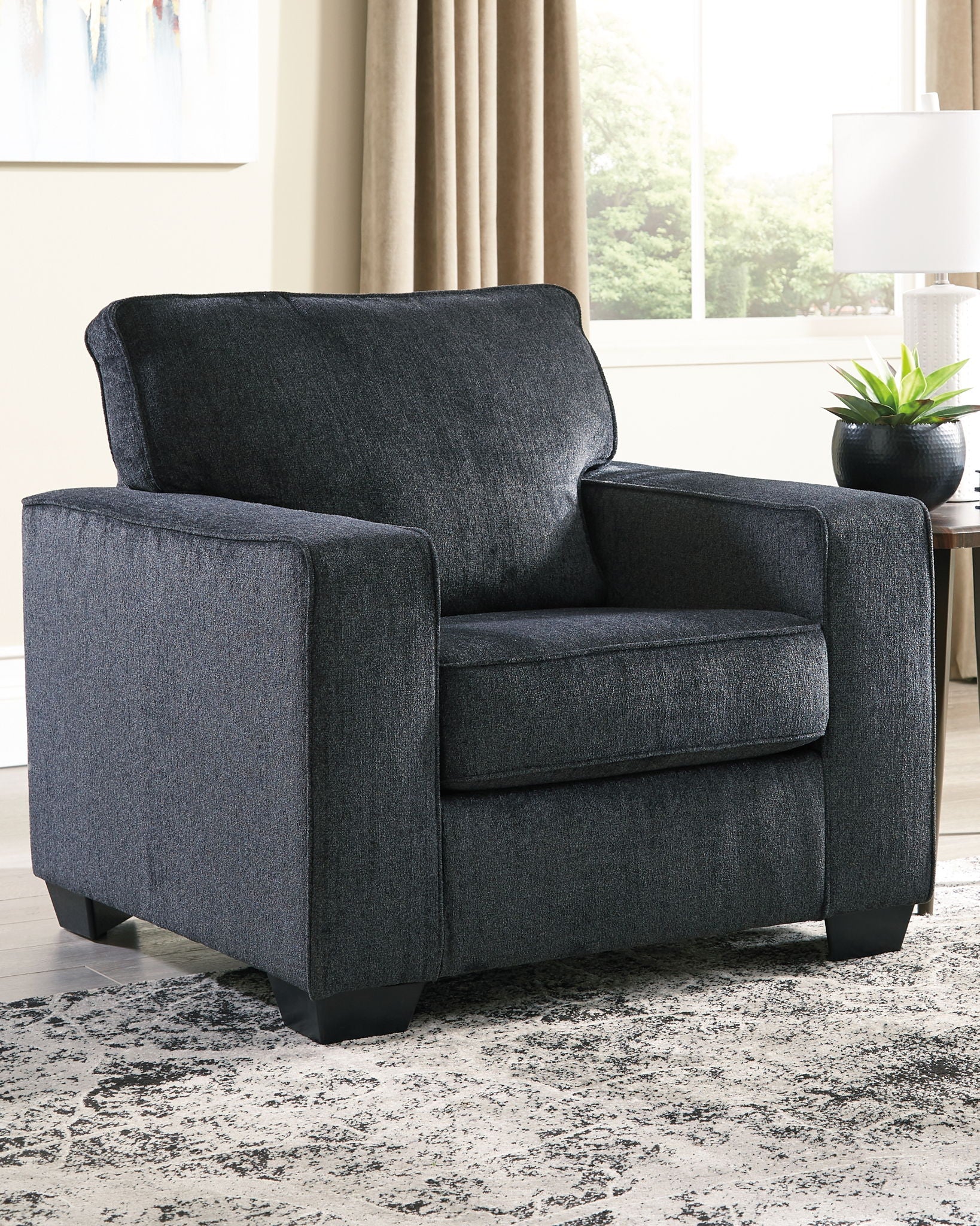 Dark gray fabric arm chair with rounded back, padded arms, and upholstered seat