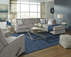 Light gray sectional sleeper sofa with chaise and stacked throw pillows in a living room