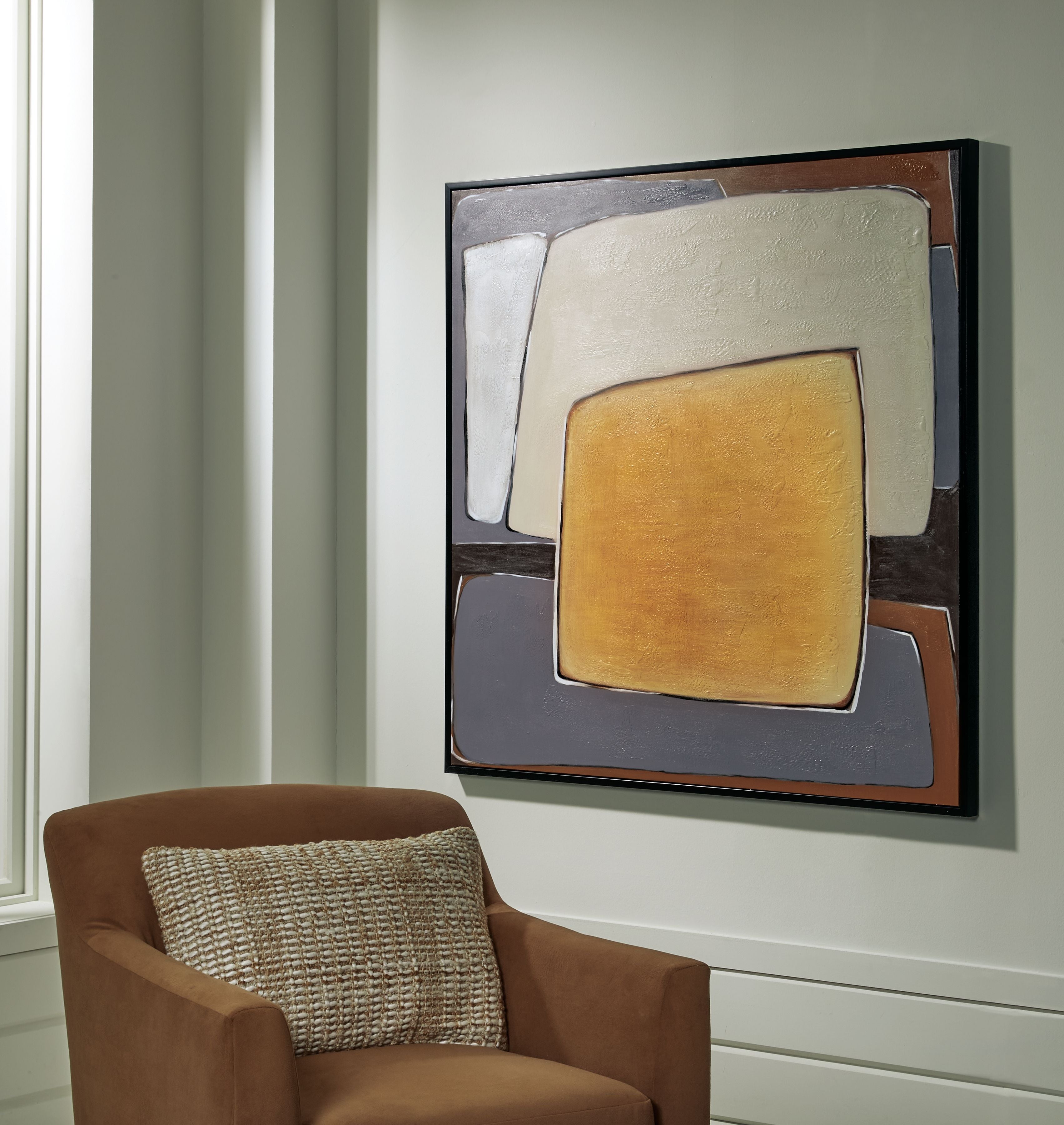 Abstract wall art hung on wall with mustard center square and cream gray panels in frame