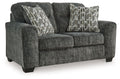 Gunmetal gray loveseat with textured fabric and three patterned accent pillows