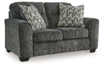 Gunmetal gray loveseat with textured fabric and three patterned accent pillows