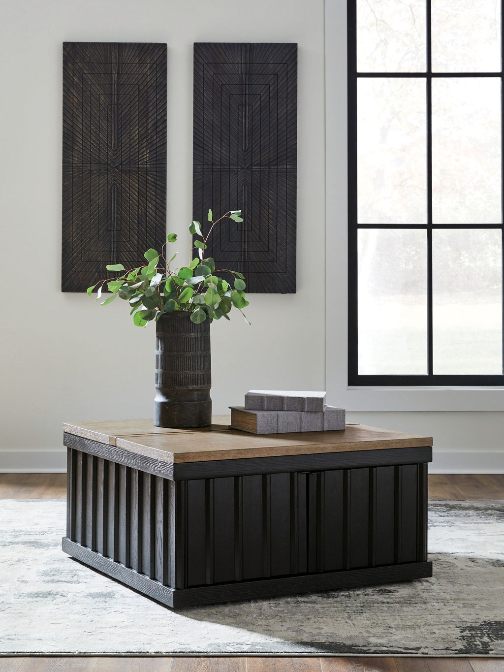 Lift-top cocktail table with light brown top and black slatted cabinet sides