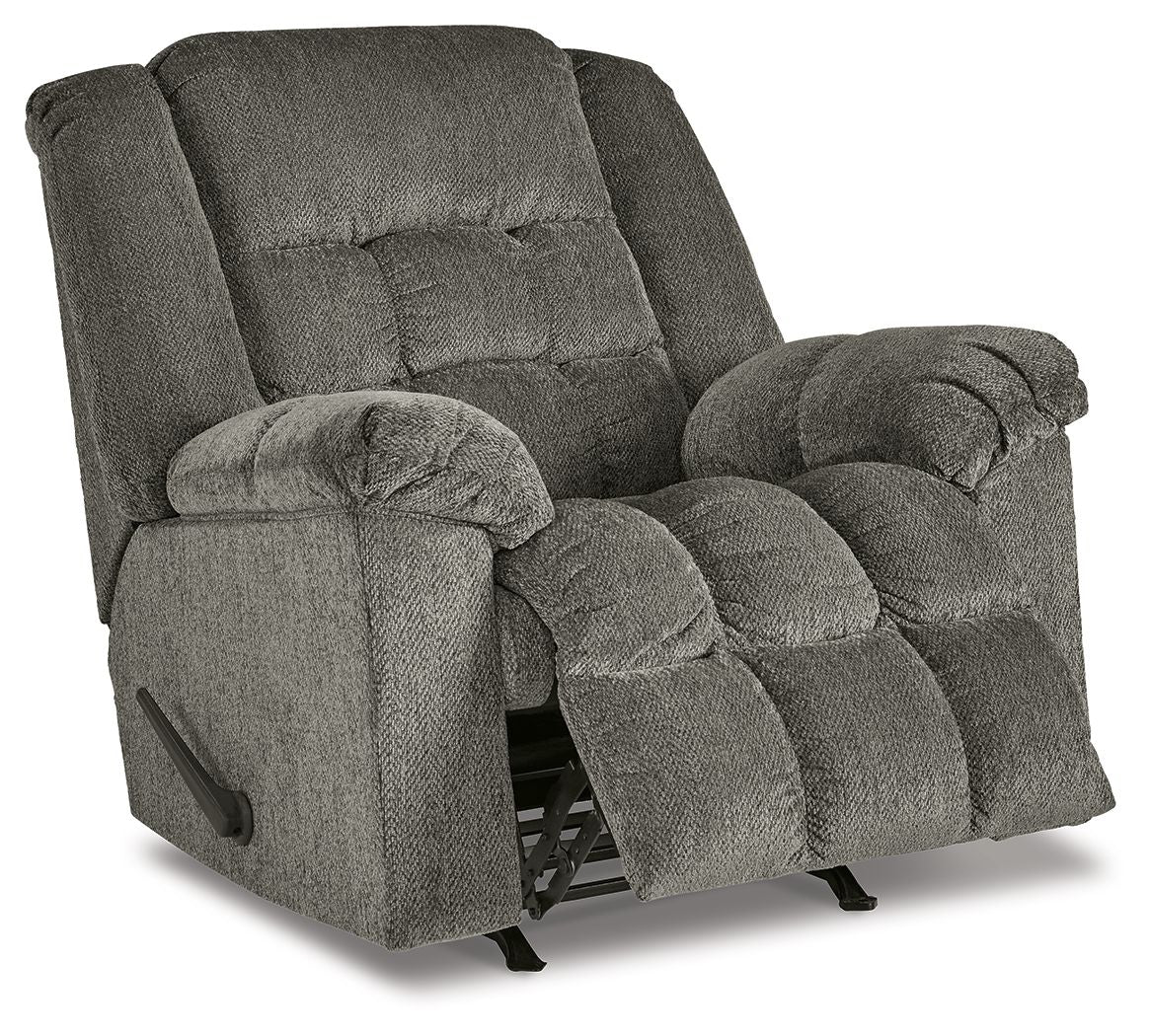 Gray rocker recliner chair with footrest extended, tufted back and padded arms