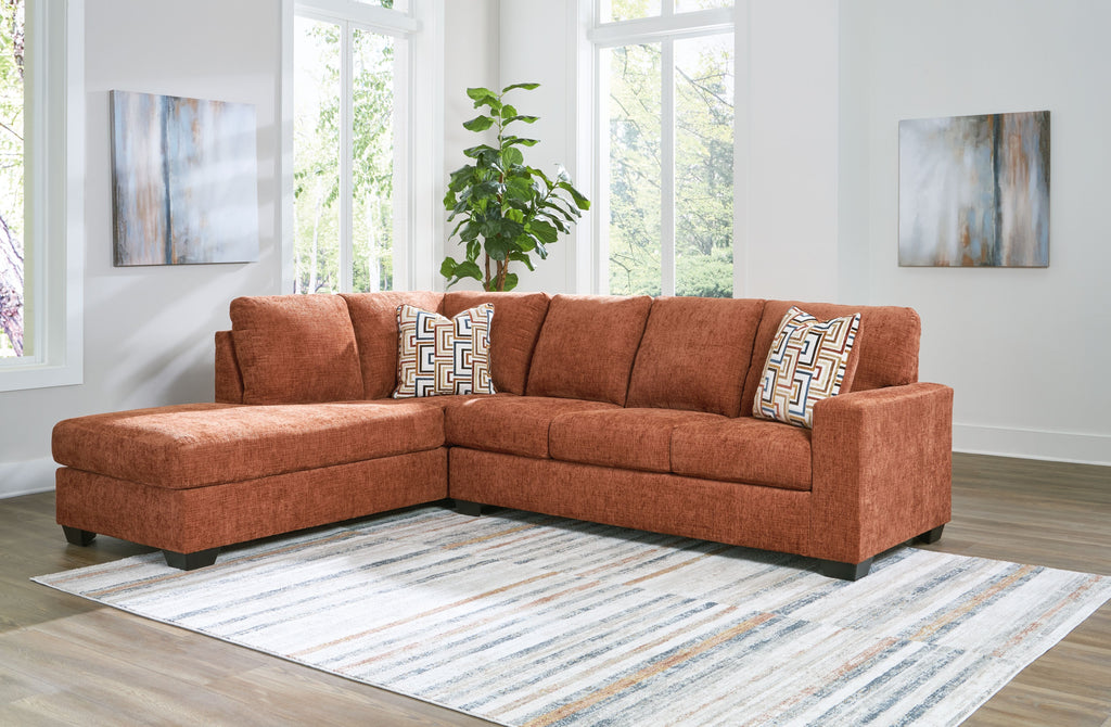 Rust-brown fabric sectional sofa with corner chaise and patterned throw pillows