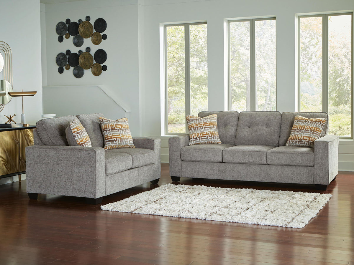 Gray living room sofa set with two seats and patterned throw pillows