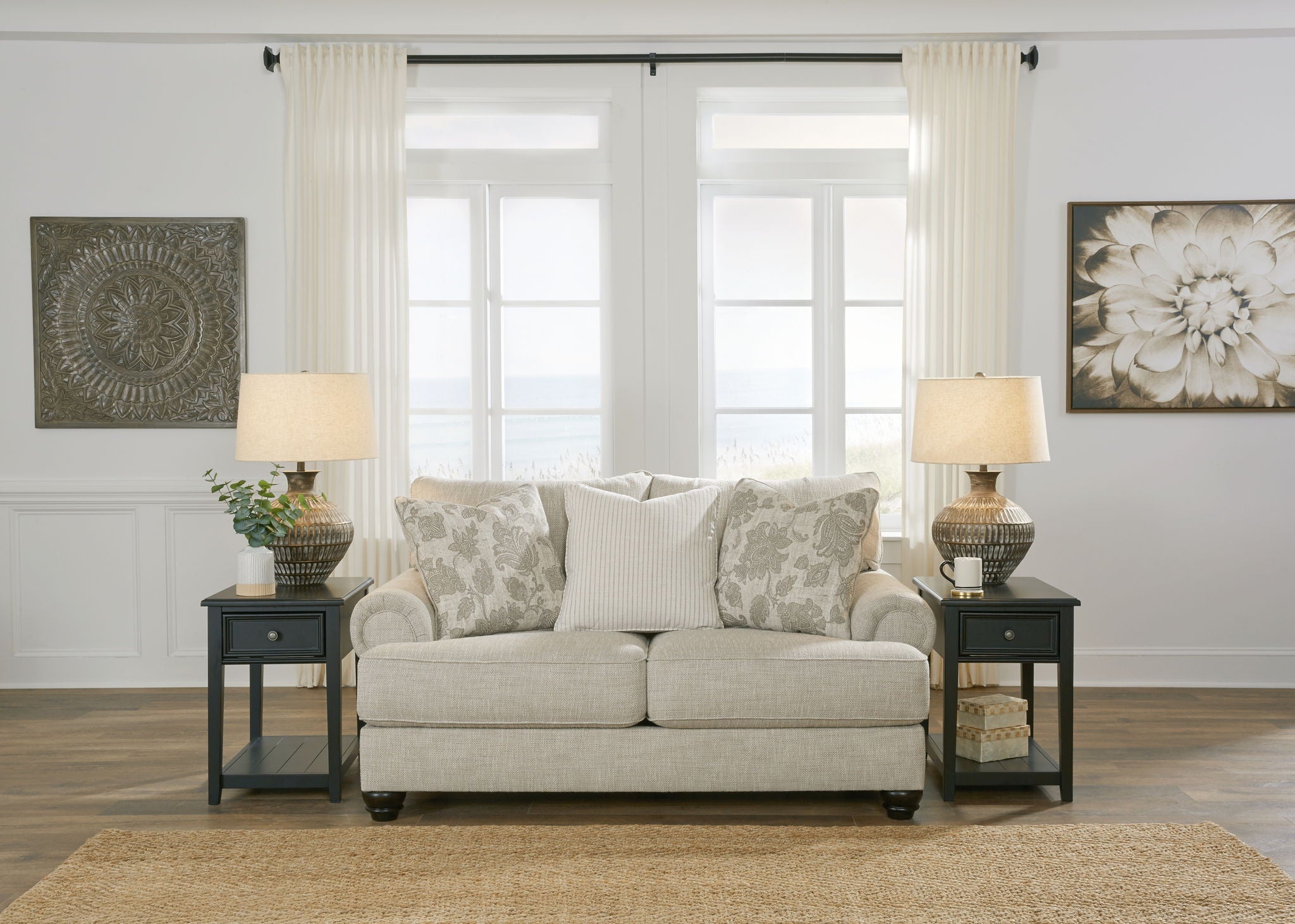 Light gray upholstered sofa with patterned pillows between matching end tables