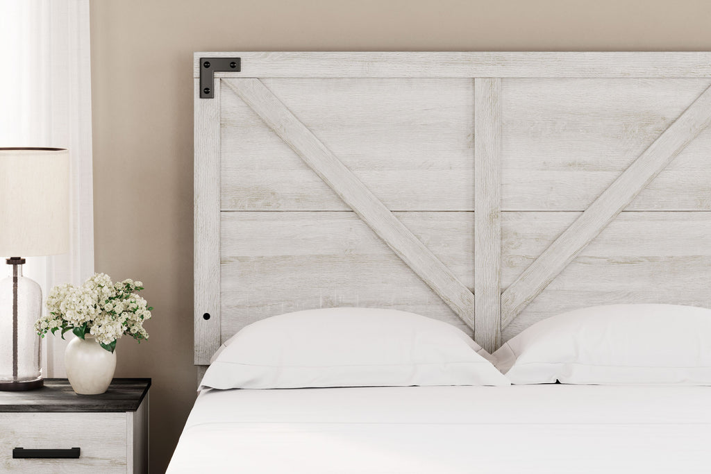 White crossbuck panel headboard behind bed with white pillow