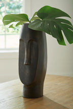 Bronze textured vase with leafy stems at top, standing upright