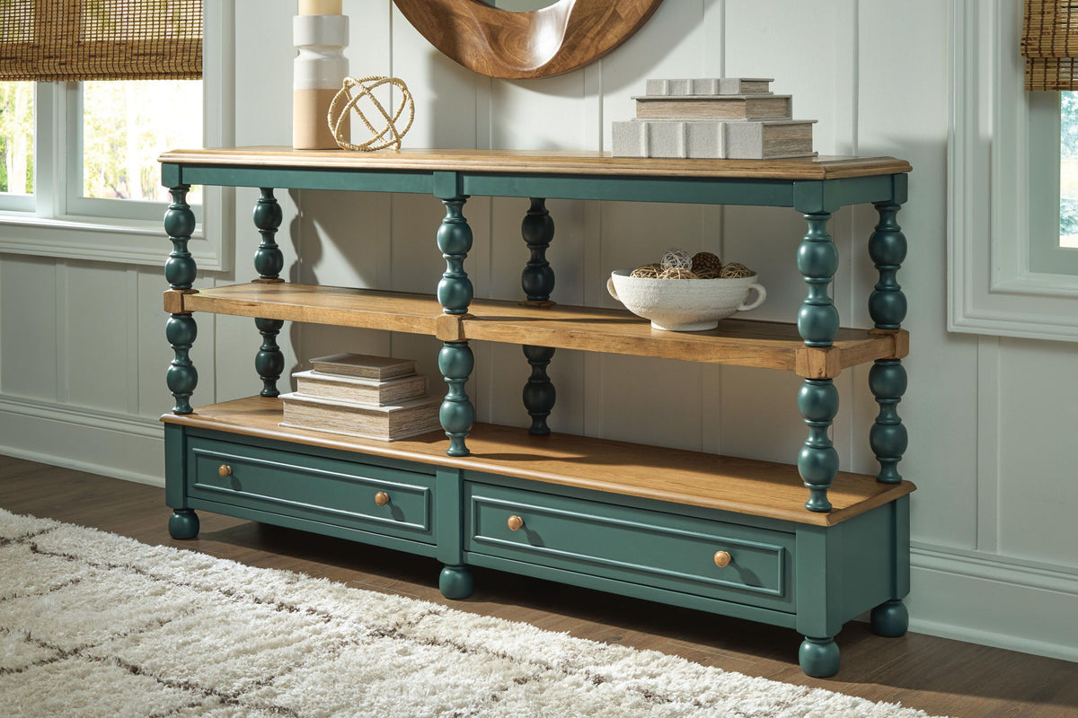 Blue console sofa table with two shelves and two drawers, styled with tabletop decor