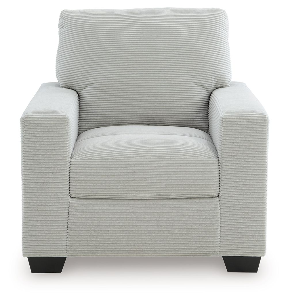 Upholstered armchair with striped upholstery, cushioned seat and arms, and dark block legs.