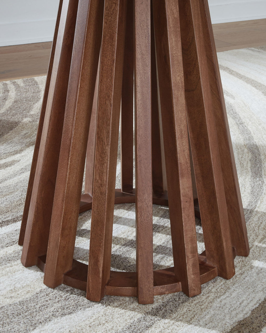 Round end table close view: warm brown legs and dark underside of round top