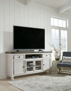 White TV stand with brown top, drawers, open shelves, and cabinet doors