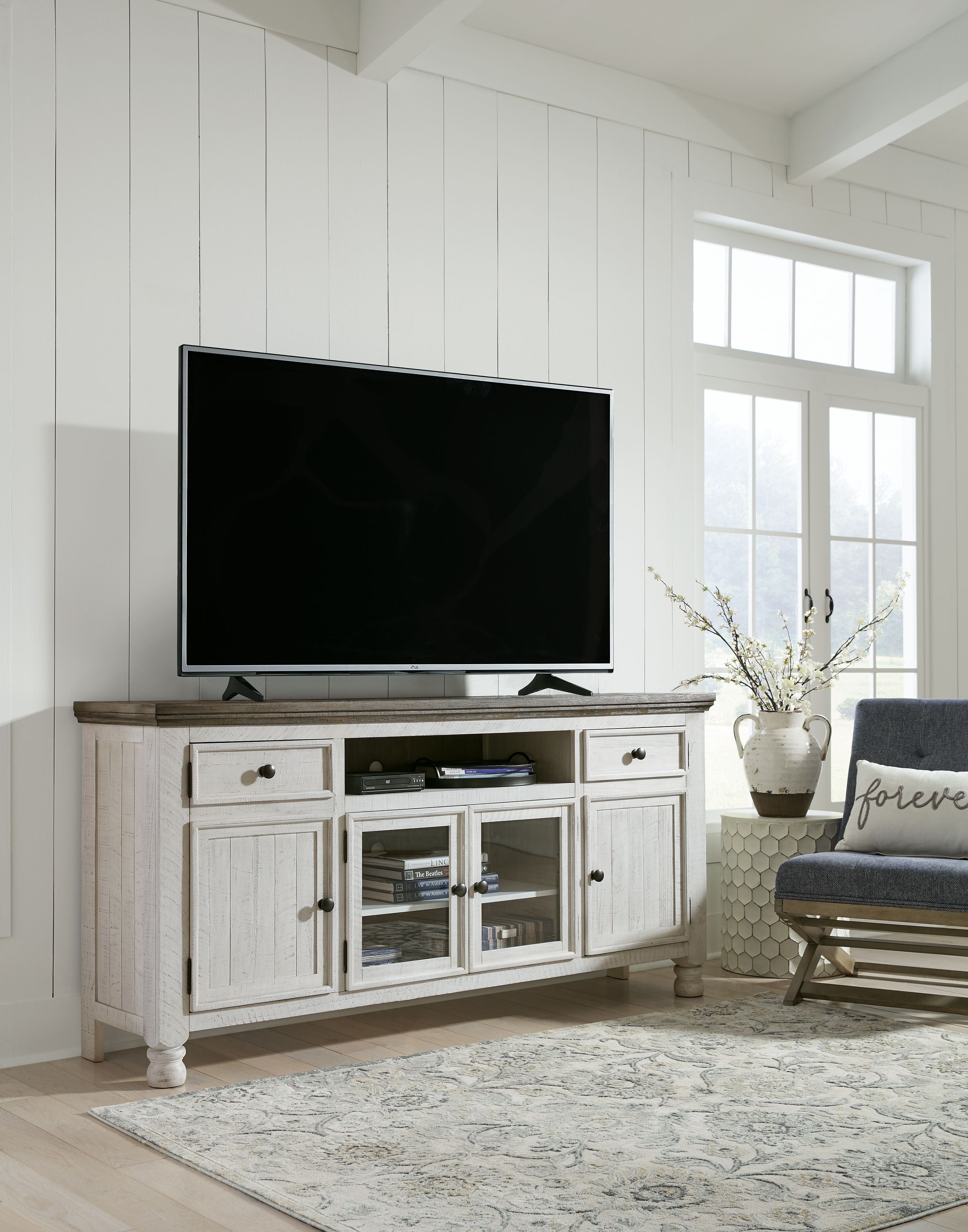 White TV stand with brown top, drawers, open shelves, and cabinet doors