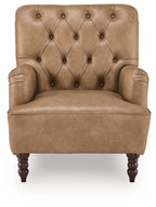 Tan upholstered accent chair with diamond tufted back, rolled arms, and dark wooden legs
