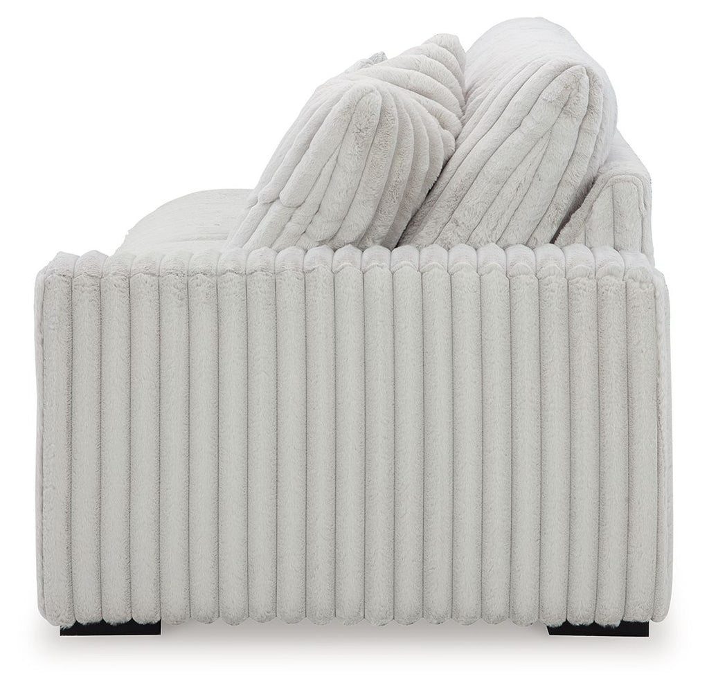 Light gray upholstered sofa back with ribbed detailing and stacked cushions