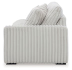 Light gray upholstered sofa back with ribbed detailing and stacked cushions