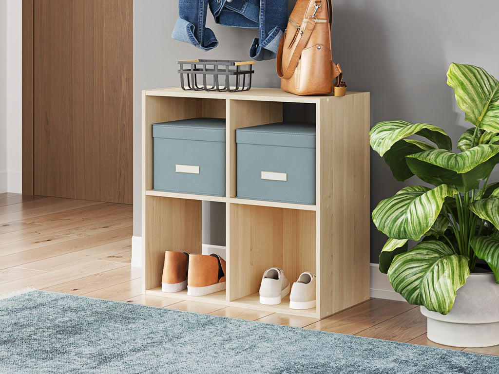 Light wood cube organizer with open compartments holding storage bins and small items