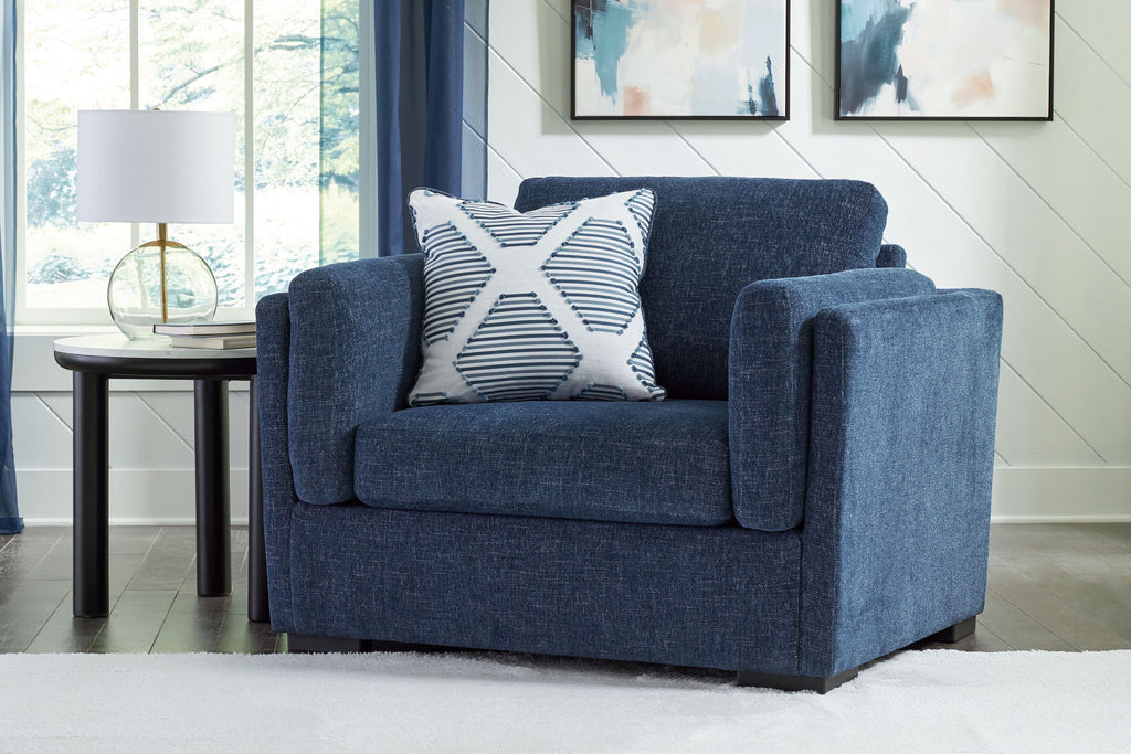 Blue upholstered chair with two striped accent pillows
