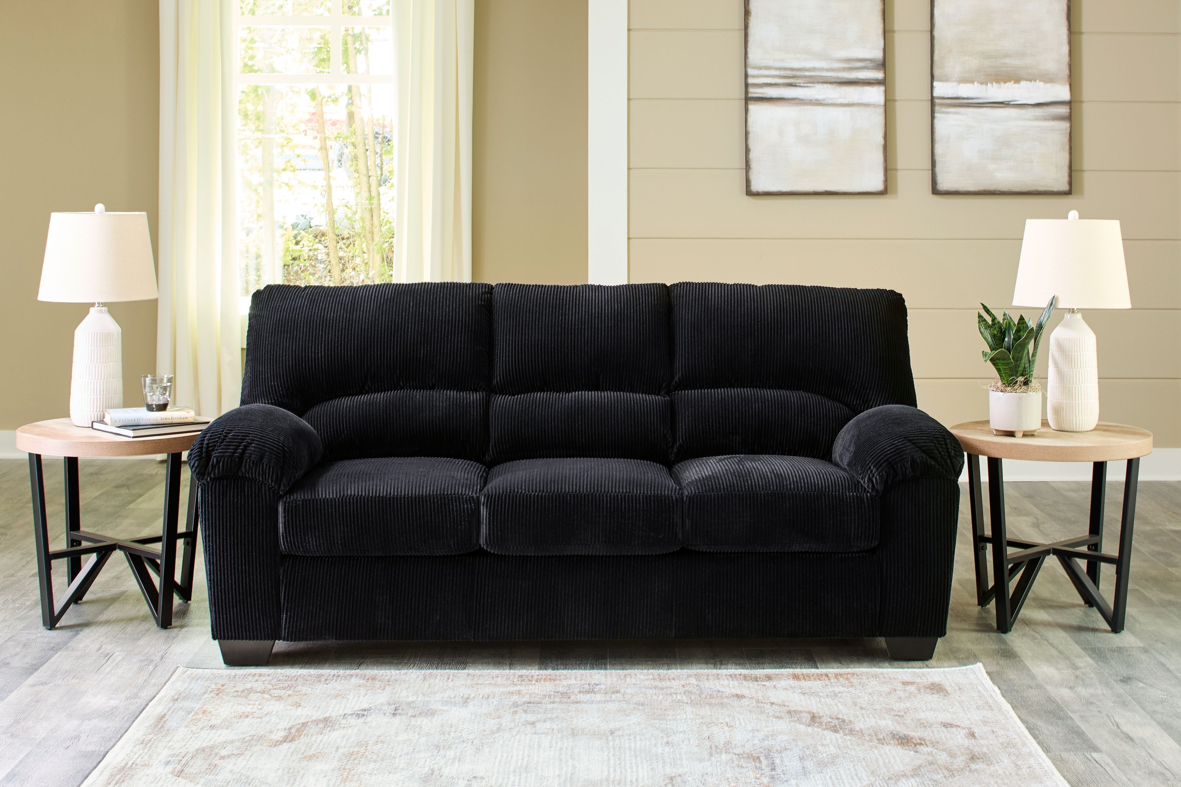 Charcoal black corduroy sofa with tufted back and rolled armrests