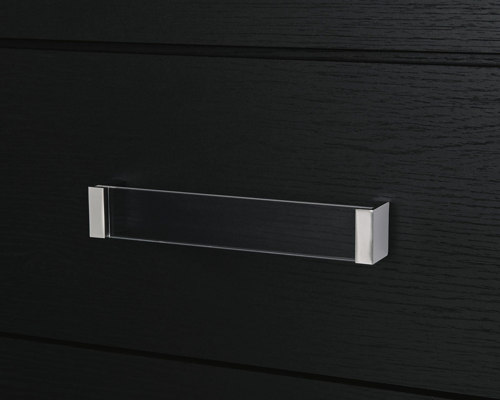 Black six-drawer dresser with silver bar pull detail on upper drawer.