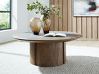 Dontayne round table with dark top and dark brown wood pedestal base in room setting.