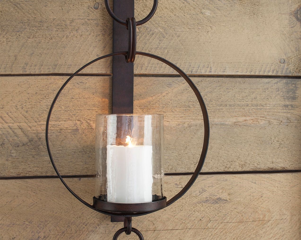 Brown wall sconce with circular metal ring and white glass cylinder light