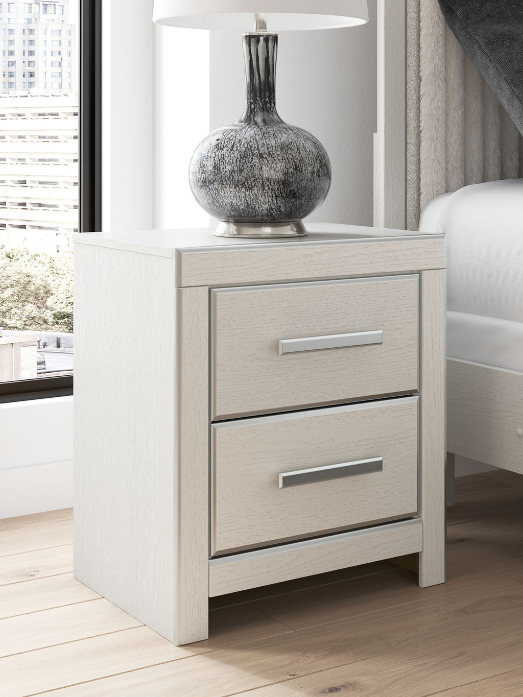 White two-drawer night stand with two silver bar handles and matching cabinet sides