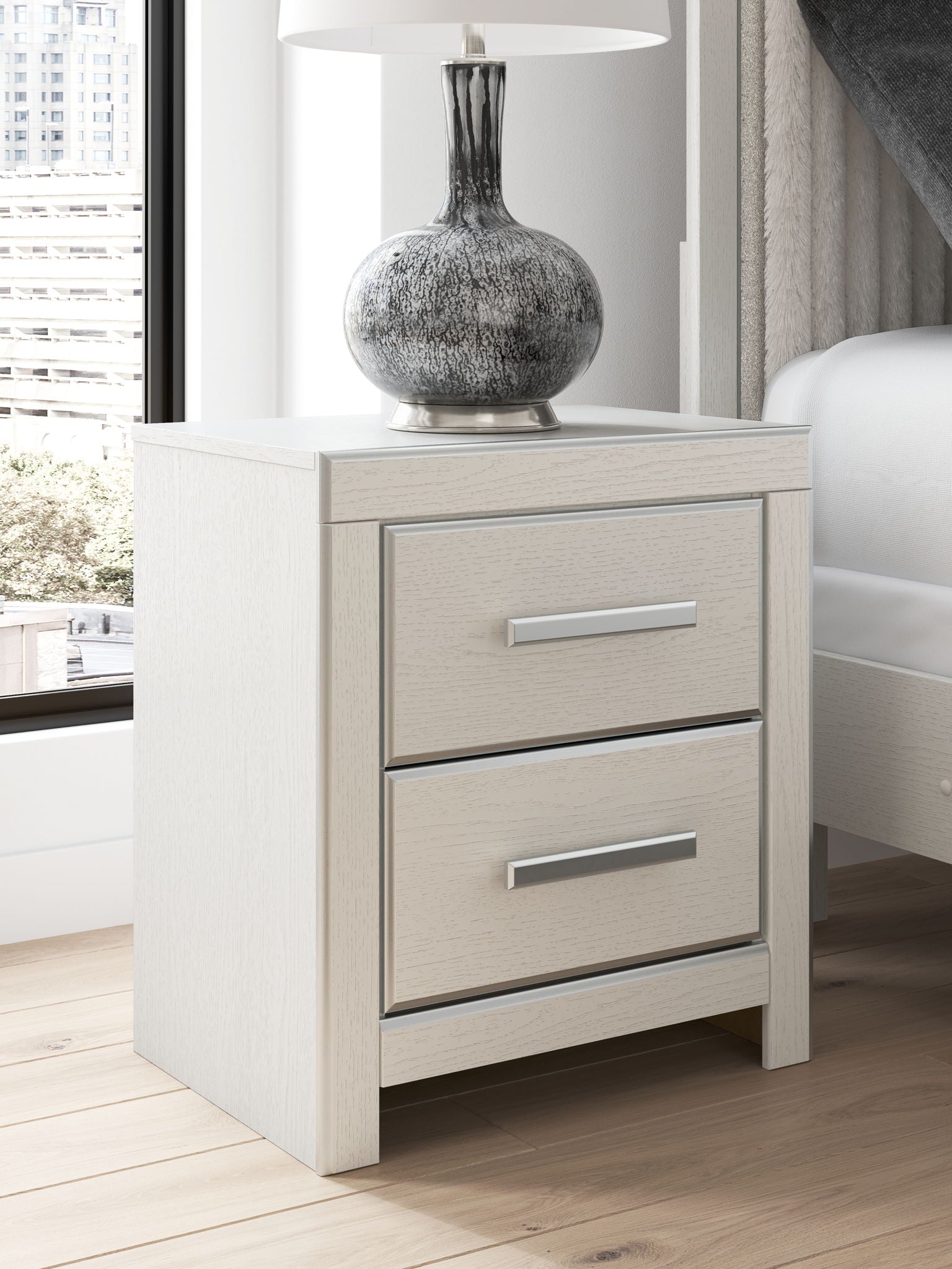 White two-drawer night stand with two silver bar handles and matching cabinet sides