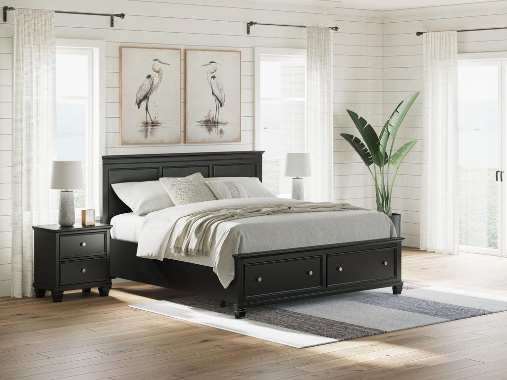 Black panel bed with drawers at the footboard and paneled headboard; gray bedding