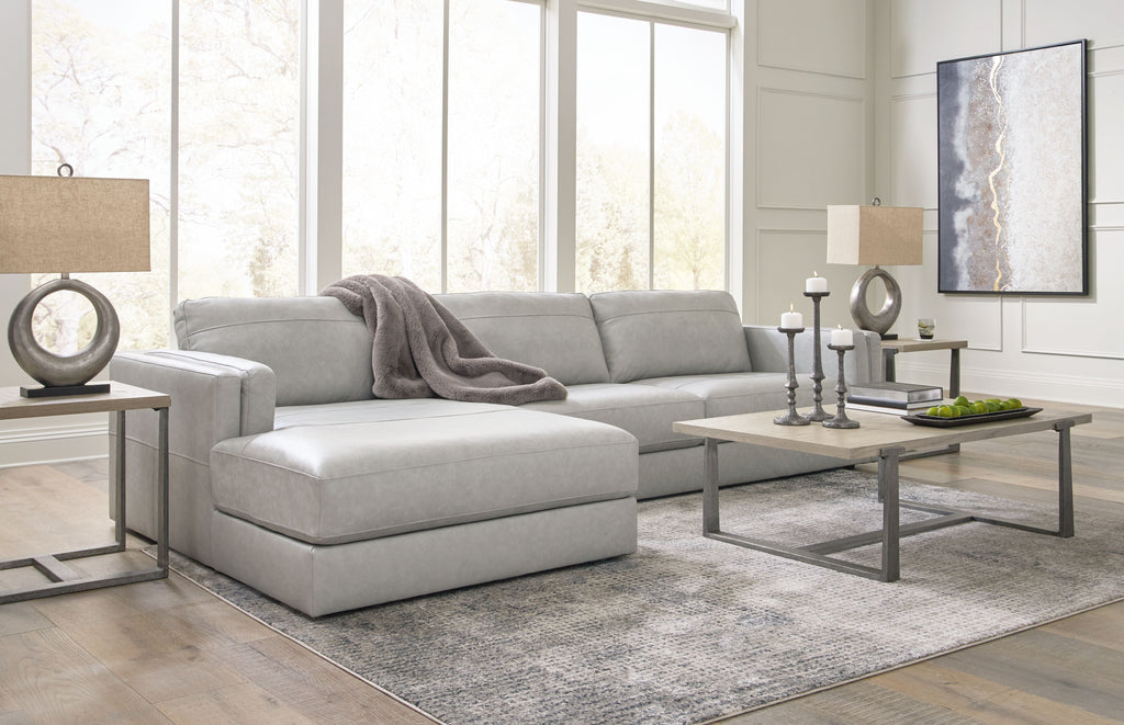 Sectional sofa with chaise lounge, light gray fabric upholstery and loose-looking throw pillow