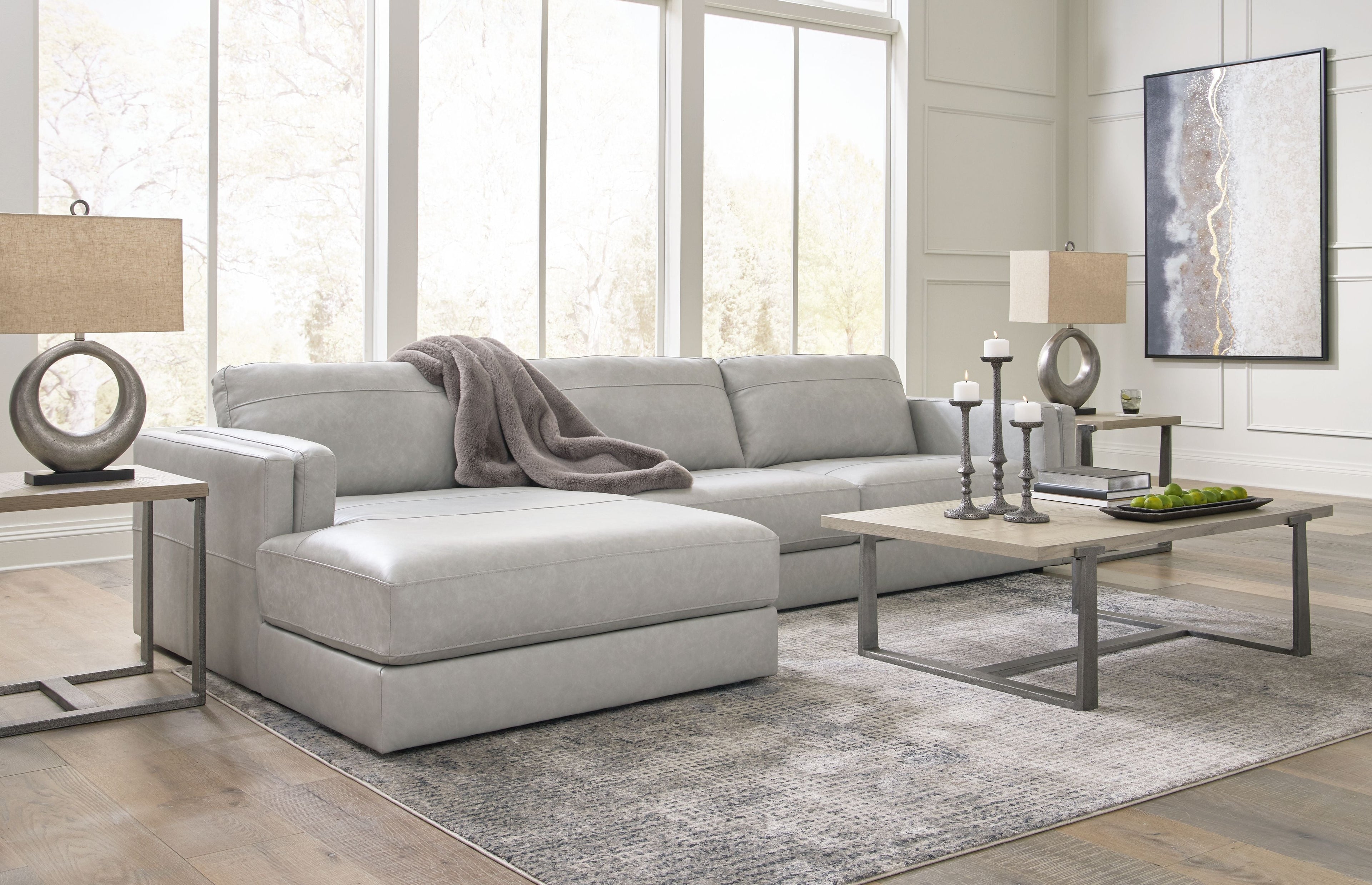 Sectional sofa with chaise lounge, light gray fabric upholstery and loose-looking throw pillow