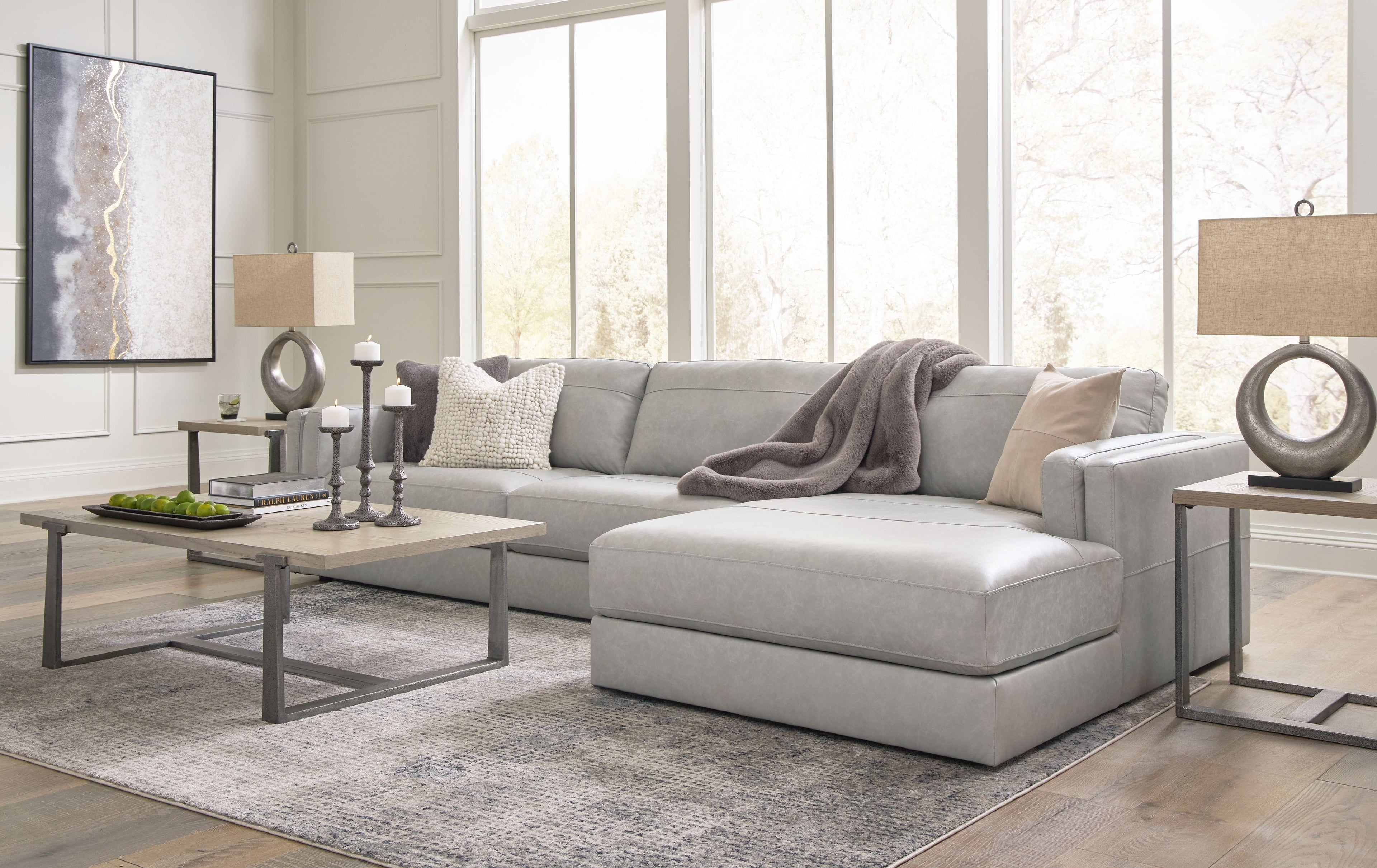 Sectional sofa with chaise lounge, light gray upholstery, rounded seat edges and back pillows