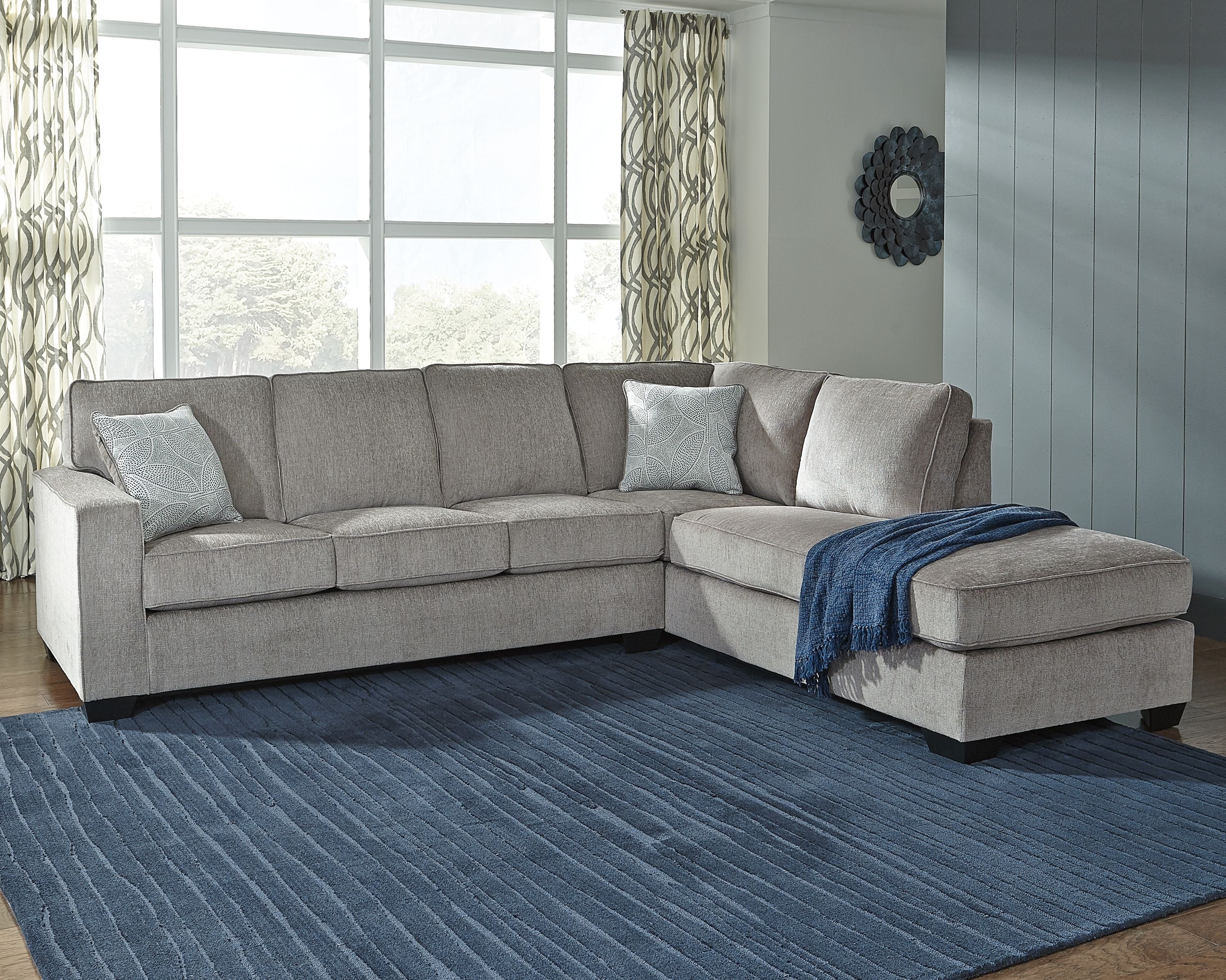 Gray sectional sofa with chaise, square arms and blue throw blanket on the ottoman