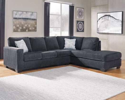 Dark gray L-shaped sectional sofa with chaise, back cushions and decorative pillows