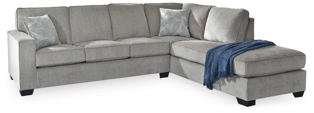 Light gray sectional sofa with chaise, blue throw blanket and textured back cushions