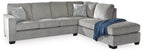Light gray sectional sofa with chaise, blue throw blanket and textured back cushions