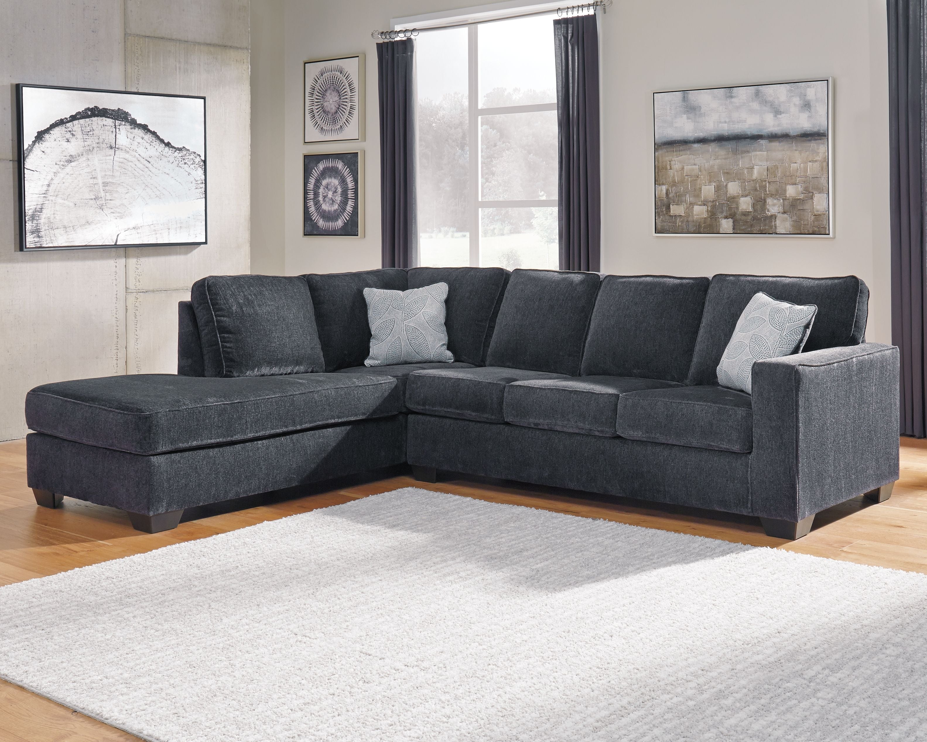 Dark slate corner sectional sofa with chaise and light throw pillows