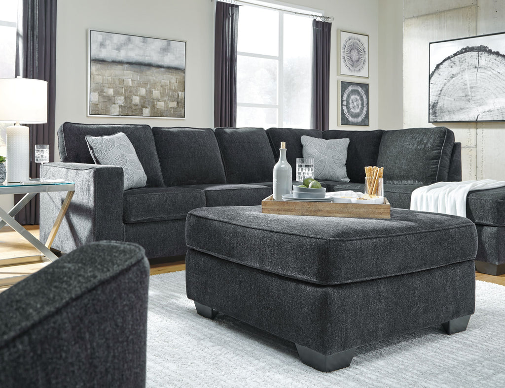 Dark slate sectional sofa with chaise and multiple throw pillows