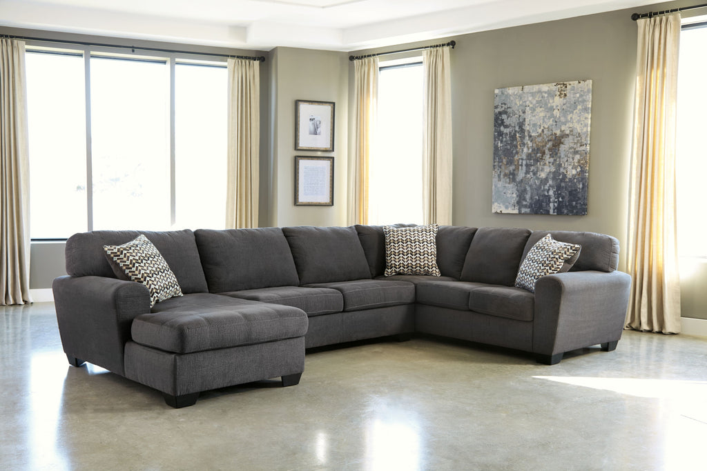 Slate sectional sofa with chaise and two patterned throw pillows on dark gray upholstery
