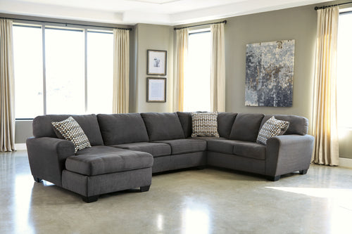 Slate sectional sofa with chaise and two patterned throw pillows on dark gray upholstery
