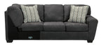 Slate three-seat sofa section with two patterned pillows and thick armrests
