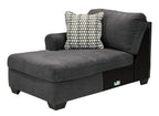 Slate chaise lounge section with one patterned throw pillow and square armrest