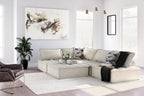 Taupe modular sectional sofa with ottoman-style chaise and multiple throw pillows