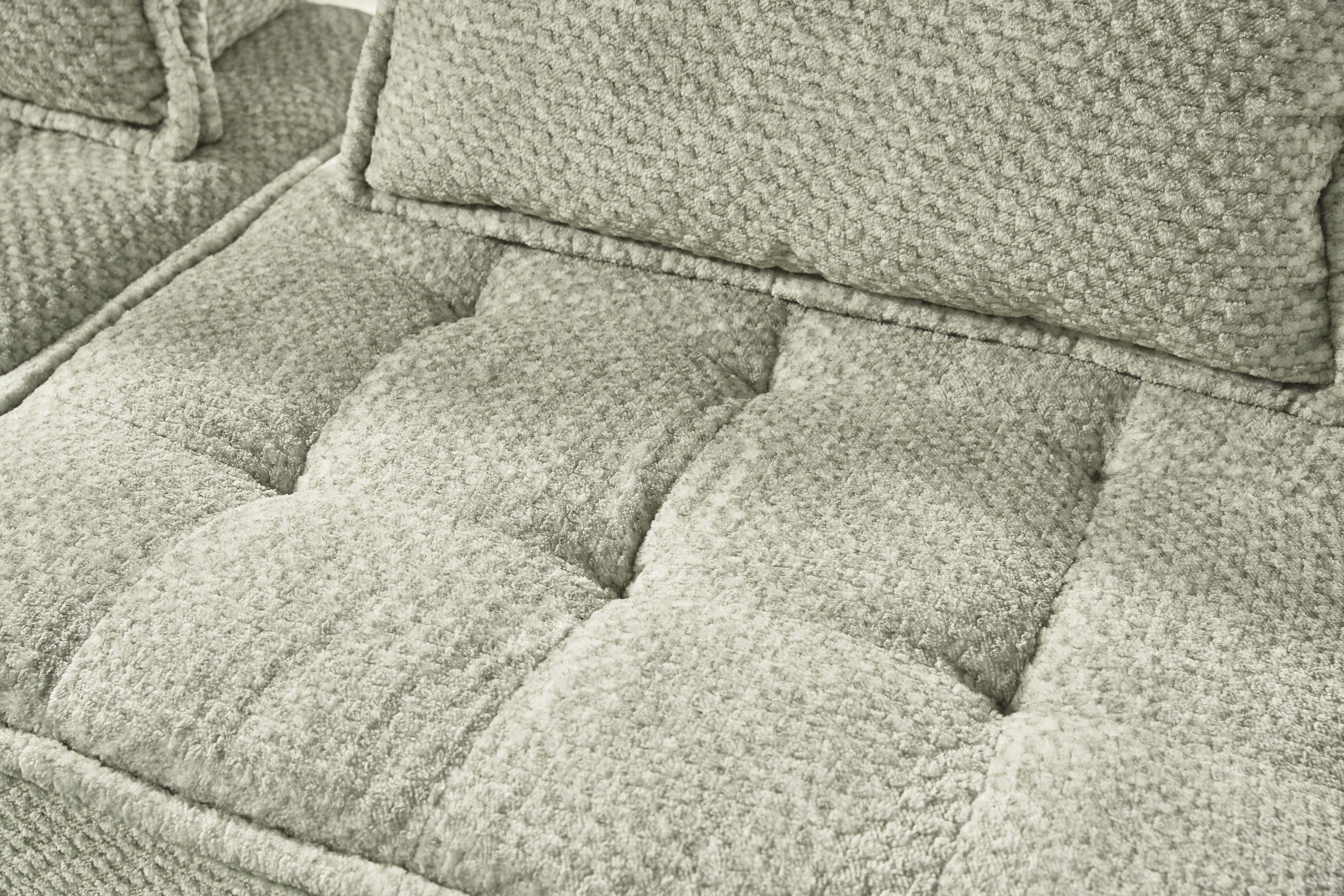 Close-up of taupe sectional seat cushions with textured fabric and stitched edges