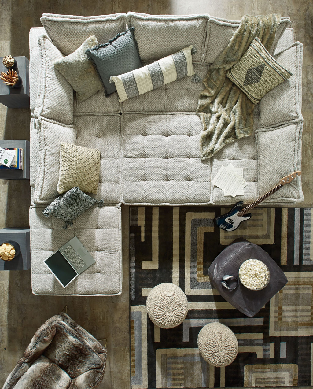 Taupe modular sectional sofa with tufted seat cushions and matching throw pillows