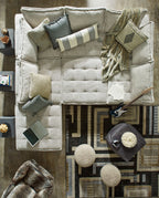Taupe modular sectional sofa with tufted seat cushions and matching throw pillows